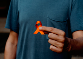 Man holding orange ribbon for multiple sclerosis