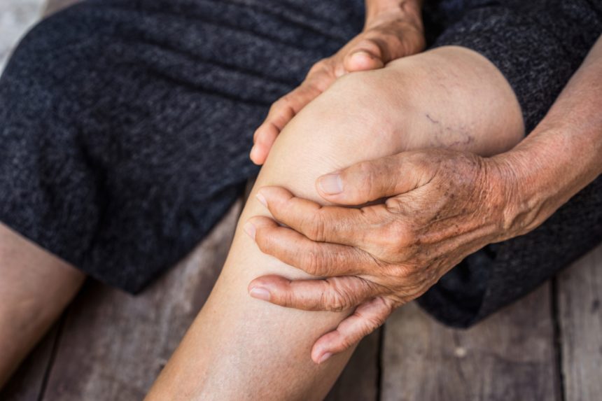 Image of a person holding knee with Osteoarthritis