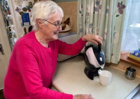 Elderly woman using the tilt to pour action of the Uccello Kettle