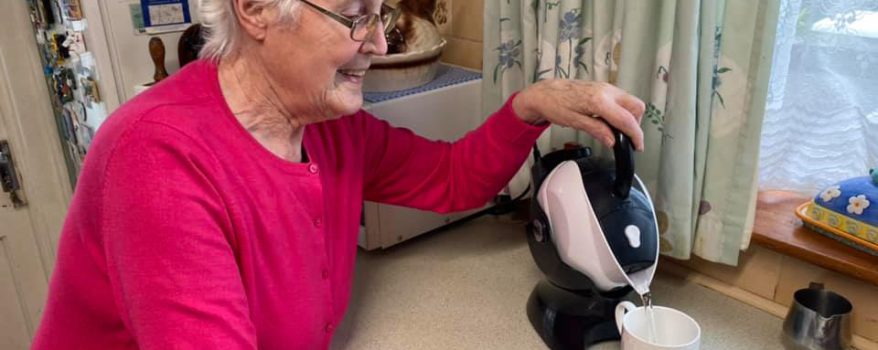 Elderly woman using the tilt to pour action of the Uccello Kettle