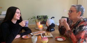 Granddaughter and grandmother sharing a conversation over a cup of tea