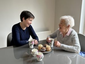Elderly Mother and daughter enjoy tea and cake together