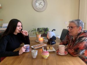 Granddaughter and Grandmother enjoying tea and cake together