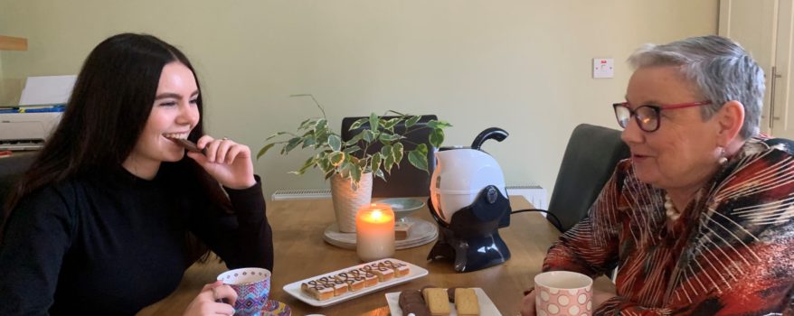 Granddaughter and Grandmother enjoying tea and cake together