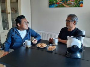 Father and son enjoying tea and biscuits in the dining room